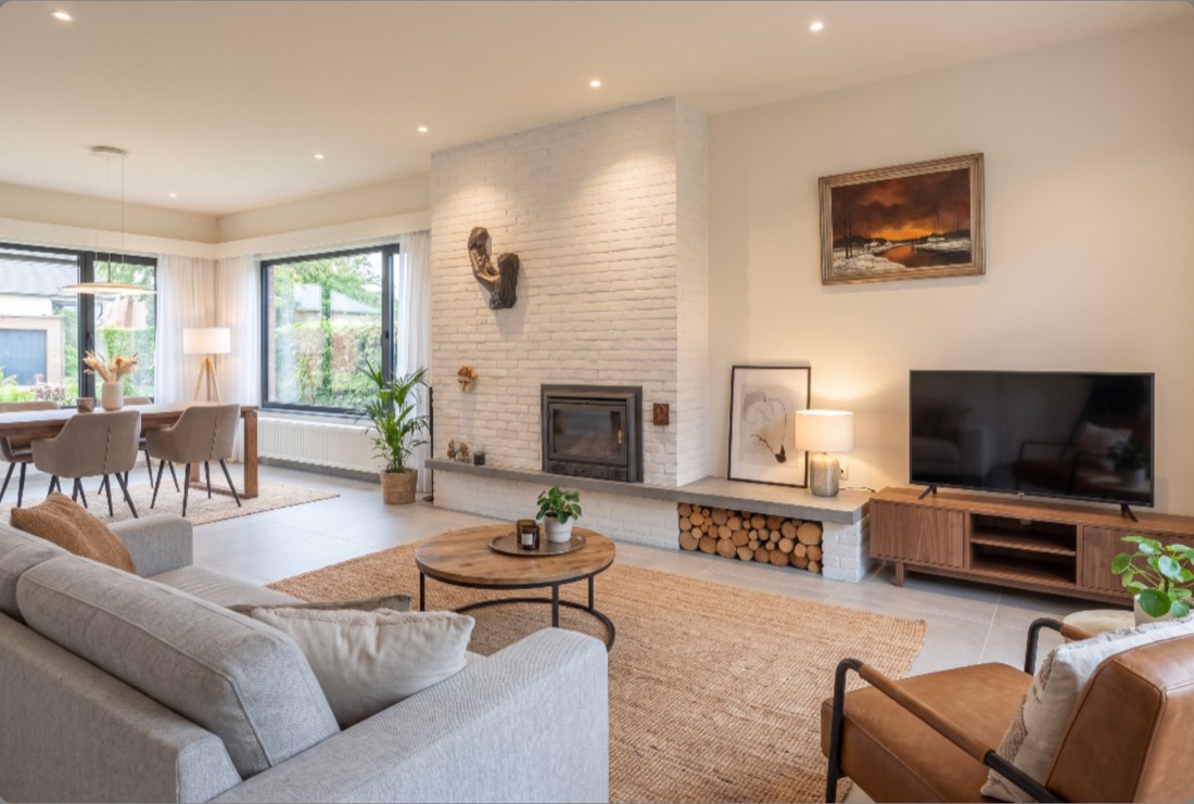 Bright living room with a white brick fireplace and large windows
